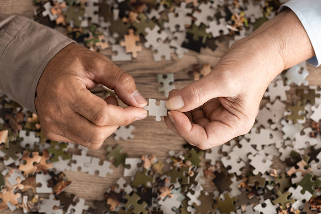 two hands holding jigsaw piece to represent pension sharing orders