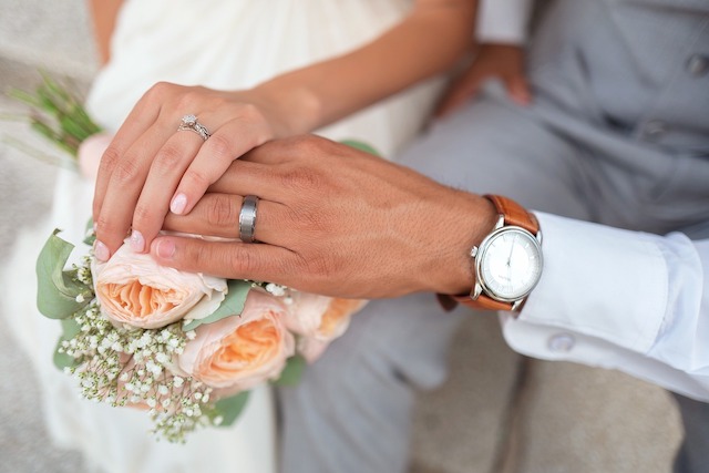 hands crossed with wedding bouquet